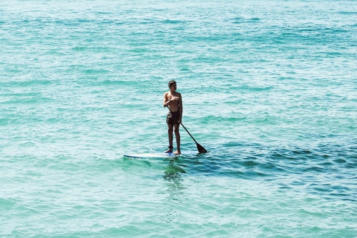 a man riding a paddleboard in the water