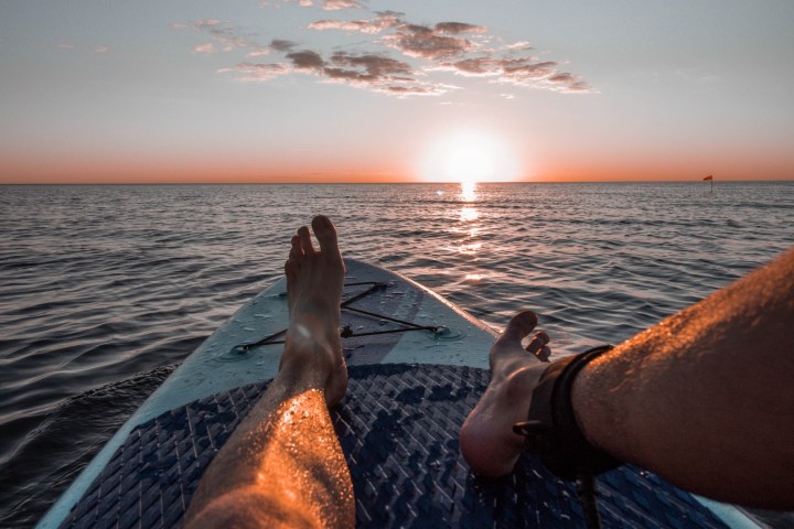 a close up of a person sitting on a paddleboard in the water