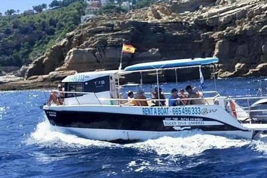 a small boat in a body of water with a mountain in the background